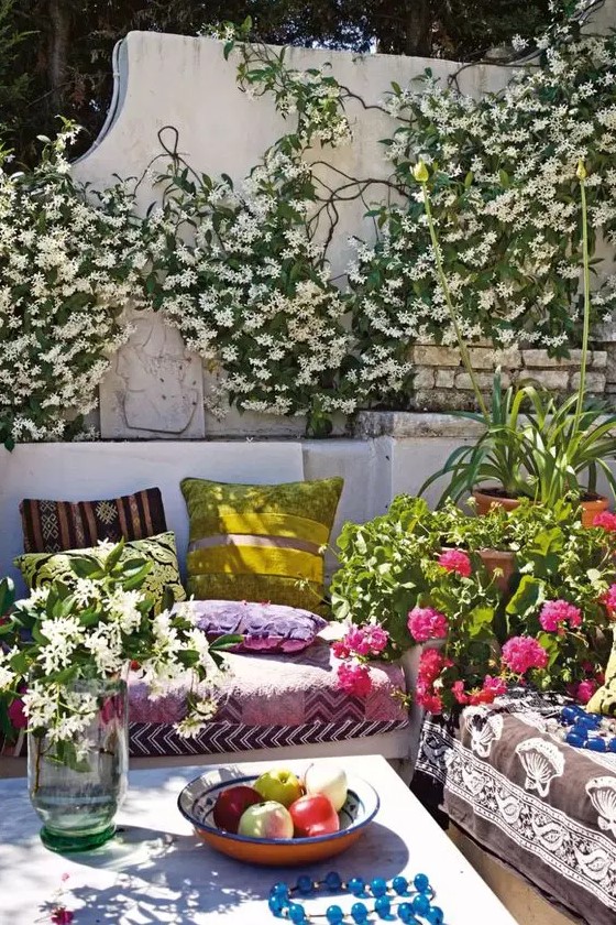 a super bold spring terrace with greenery and blooms, with colorful textiles, potted plants and colorful pillows