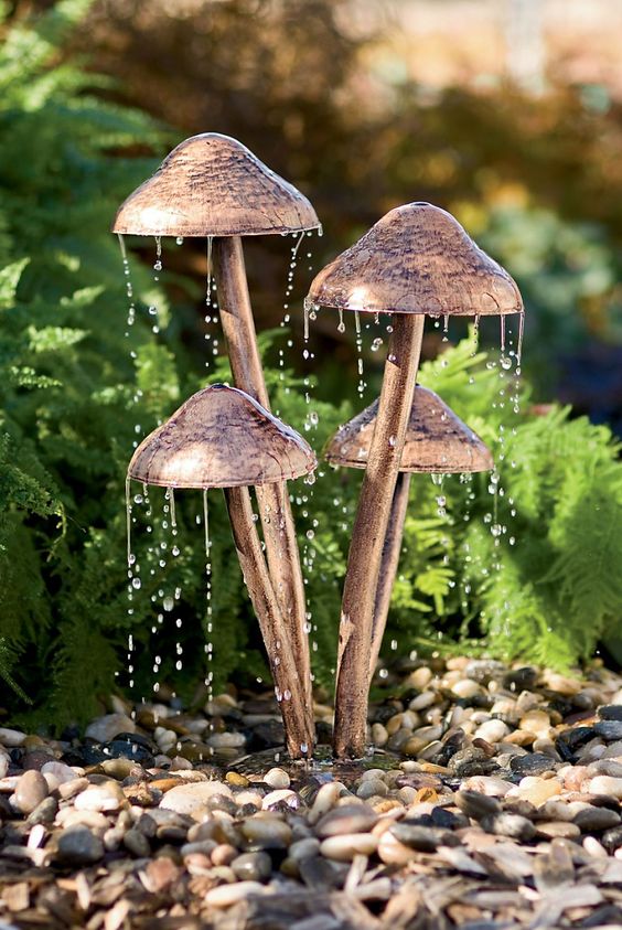 a super creative fountain composed of faux mushrooms and with pebbles around will be a great idea for a woodland-themed garden