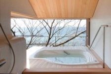 an outdoor-indoor minimalist bathroom with an asymmetrical bathtub, a view and a terrace to enjoy the views as much as possible
