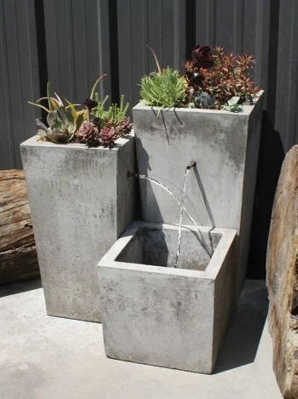 an ultra-modern or minimalist fountain composed of tall concrete planters is a stylish solution for a modern space