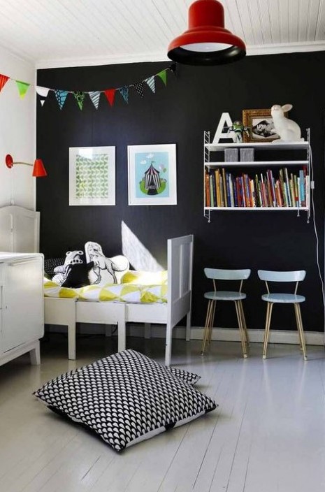 a Nordic kid's room with vintage white furniture, a wall shelf, a black statement wall, colorful books and buntings