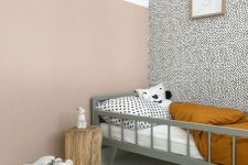 a Nordic kid’s space done with plenty of color and print, with a grey bed and printed bedding, a printed wall, a tree stump and a printed rug