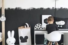a Scandinavian kid’s room with a partly black and partly white wall with a brushstroke pattern