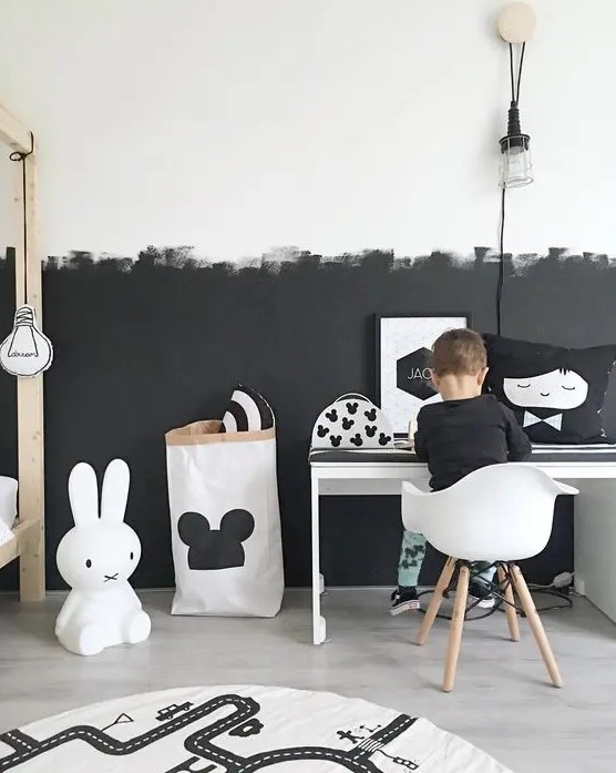 a Scandinavian kid's room with a partly black and partly white wall with a brushstroke pattern