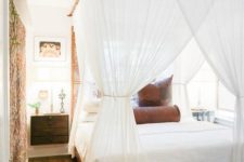 a bed with a bamboo frame and a mosquito net canopy that keeps bugs away and add colonial style to the bedroom
