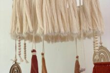 a boho nursery mobile with neutral tassels, colorful tassels and beads, rainbows is a cool idea for a boho space