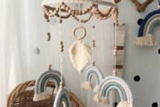 a catchy tiered boho mobile with wooden beads, a macrame monstera leaf, blue rope rainbows is a lovely idea