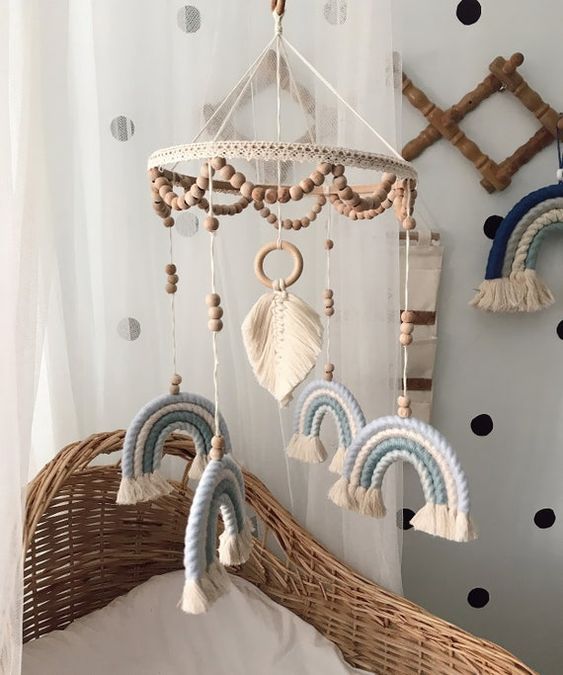a catchy tiered boho mobile with wooden beads, a macrame monstera leaf, blue rope rainbows is a lovely idea
