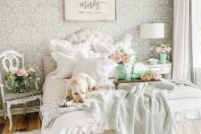 a charming pastel bedroom with sophisticated white furniture, pastel bedding, lots of blooms and a crystal chandelier