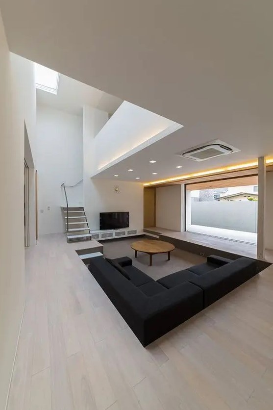 a clean minimalist space with a sunken conversation pit with much negative space for an airy feeling