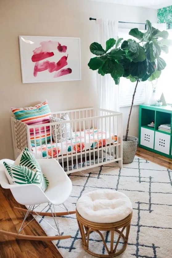 a colorful tropical-inspried small nursery with floral, palm prints, potted greenery and artworks