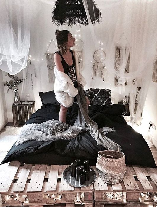 a contrasting boho bedroom with mosquito net curtains, dream catchers, dried herbs and wicker baskets