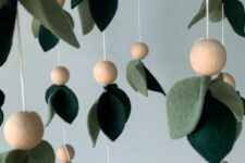 a cool green felt leaf mobile with wooden beads is a cool idea with a botanical touch, it will work for most of nurseries