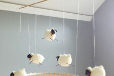 a cool kid mobile with a fence and some crochet sheep is a fun and cool idea that works for every nursery