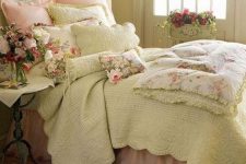 a cozy French country and shabby chic bedorom with a crystal pendant lamp, chic furniture, pastel bedding and lots of blooms