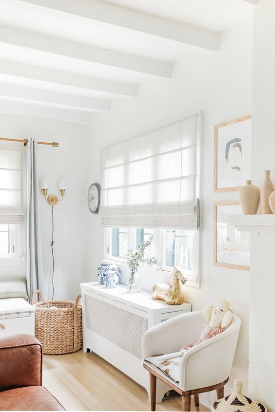 a cozy and serene kid's bedroom with a neutral Roman shade and neutral furniture looks welcoming and very airy