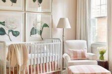 a cozy farmhouse nursery with peach and white plaid textiles and flower artworks may be nice for a girl’s space