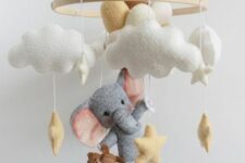 a cute and delicate mobile with clouds, an elephant with balloons and stars, a little teddy bear is a super fun and cool idea