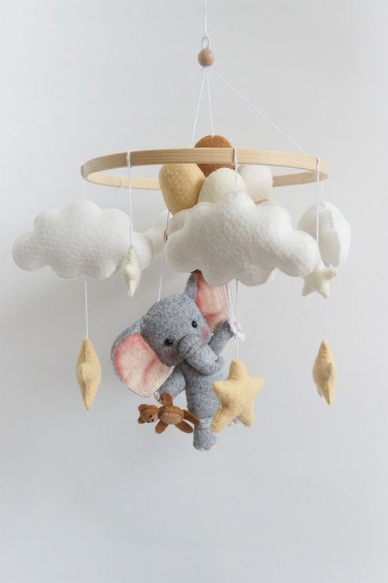 a cute and delicate mobile with clouds, an elephant with balloons and stars, a little teddy bear is a super fun and cool idea