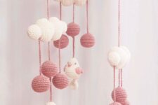 a cute pink and white crochet mobile with clouds, pompoms and birds is a lvoely idea for any kids’ space