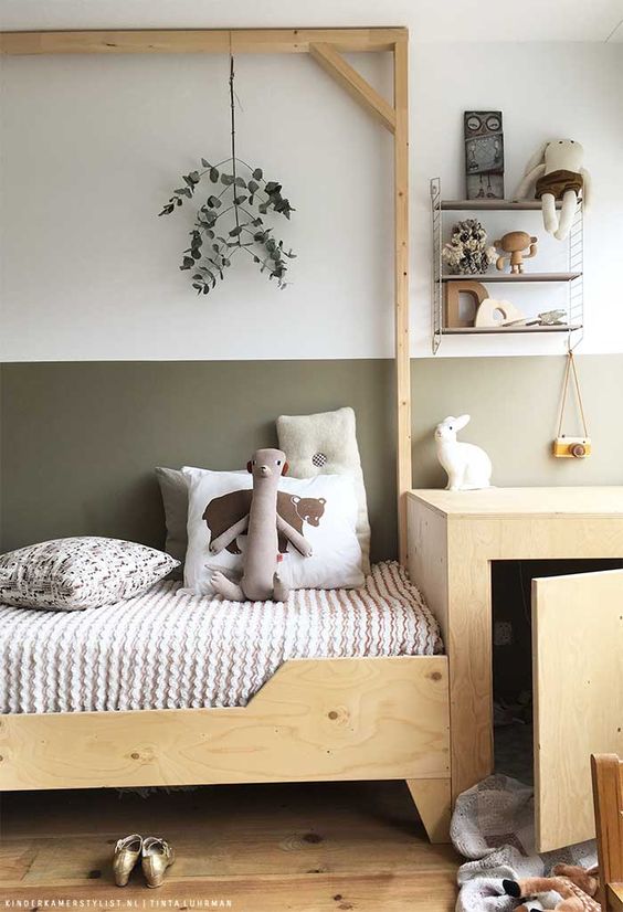 a delicate and neutral Scandi kid's room with color block walls, stained furniture, open shelves and toys and decor that match