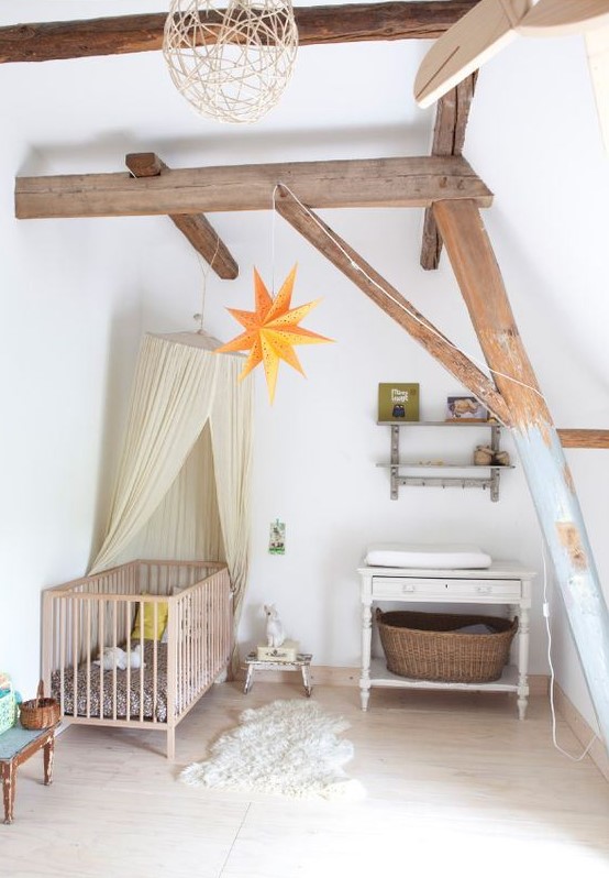 a dreamy attic nursery with wooden beams, vintage furniture, a canopy, stars and baskets plus a cute rug