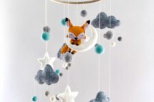 a dreamy nursery mobile with felt clouds, stars, raindrops and a fox sitting on the moon is extremely cool and cute