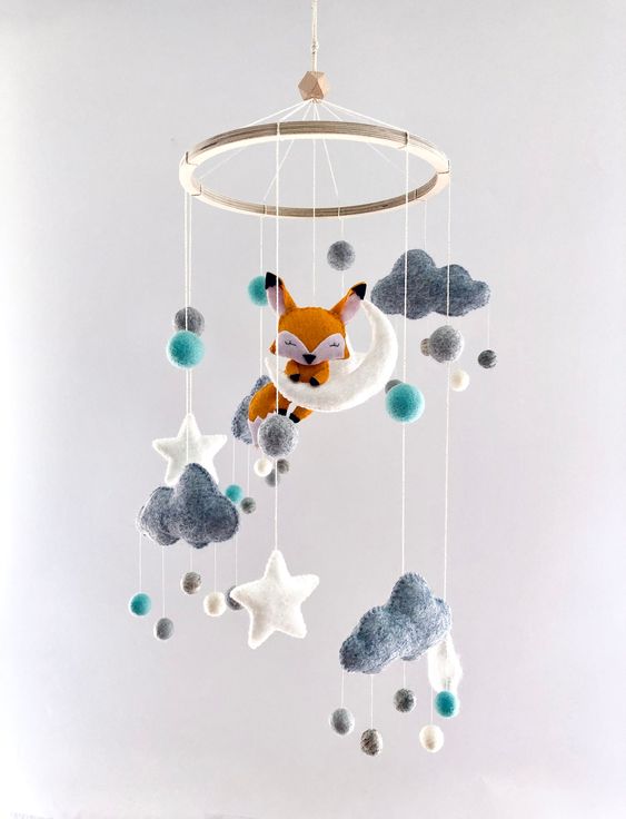 a dreamy nursery mobile with felt clouds, stars, raindrops and a fox sitting on the moon is extremely cool and cute