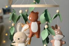 a felt woodland nursery mobile with leaves and pompoms, felt animals is a stylish and catchy idea for a woodland space