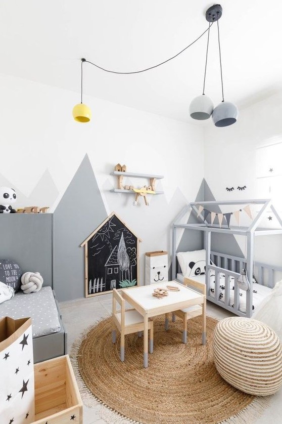 a fun and cool Scandinavian kids' room with two beds, walls with mountain art, pendant lamps, wooden boxes with stars