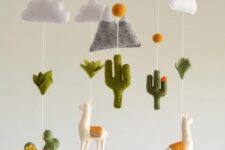 a fun desert boho mobile with felt cacti, llamas, a mountain, clouds and pompoms is a cool and bold solution for a desert space
