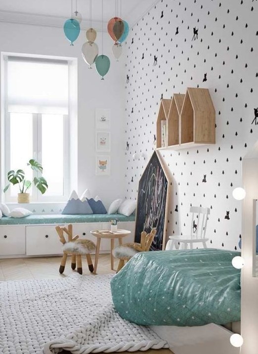 a girl's Scandinavian bedroom with a windowsill daybed, a kid's bed, some house-shaped shelves, a little table and chairs