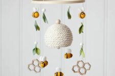 a honey-themed nursery mobile with a hive, bees, honey combs, felt and wooden beads and is a cool idea for a honey-themed nursery