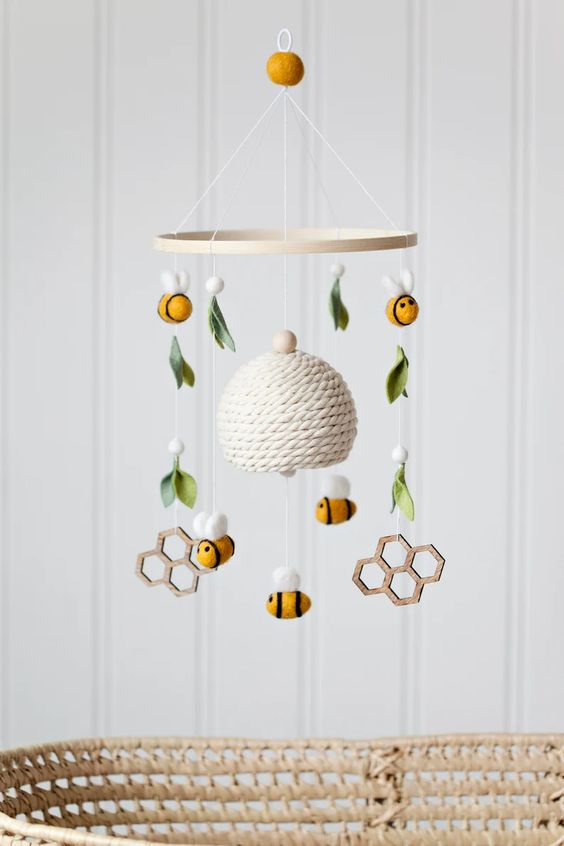 a honey themed nursery mobile with a hive, bees, honey combs, felt and wooden beads and is a cool idea for a honey themed nursery