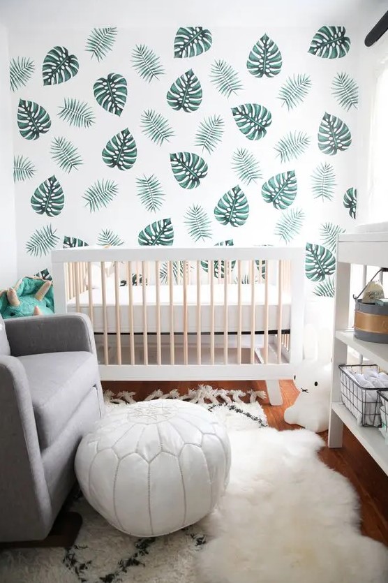 a leaf print wall, faux fur, a white leather ottoman and lots of natural light for a clean look in a tiny nursery