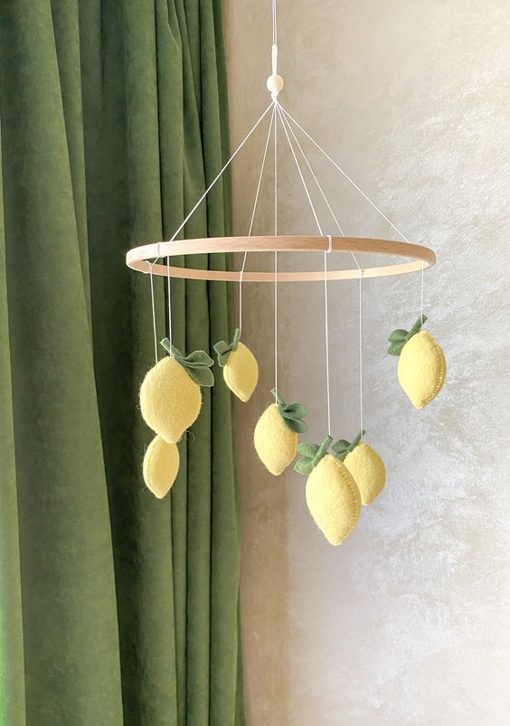 a lovely and bold yellow felt lemon mobile with leaves is a cool and chic idea for a botanical themed space or a Mediterranean one