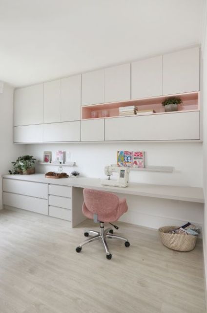 a minimalist white home office with sleek cabinetry, open storage units, a built in desk with much storage and a basket for stuff