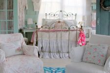 a neutral and pastel shabby chic bedroom with a forged bed, a minty door, floral bedding and white furniture