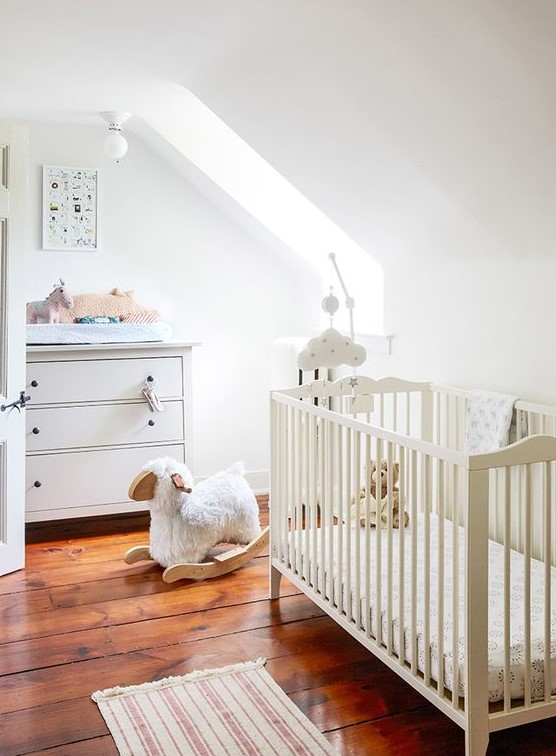 a neutral attic nursery with simple and casual furniture, muted and printed textiles plus lots of cute toys