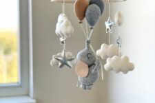a neutral baby mobile with clouds and stars, with an elephant flying with balloons is a very cute and fun idea