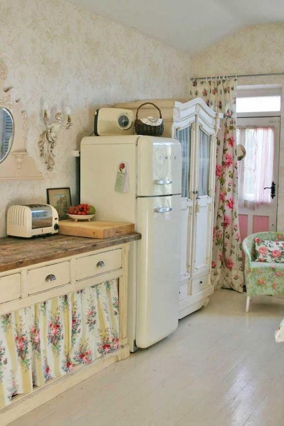 a neutral shabby chic space with refined vintage furniture, floral curtains instead of doors, floral textiles and a wall sconce