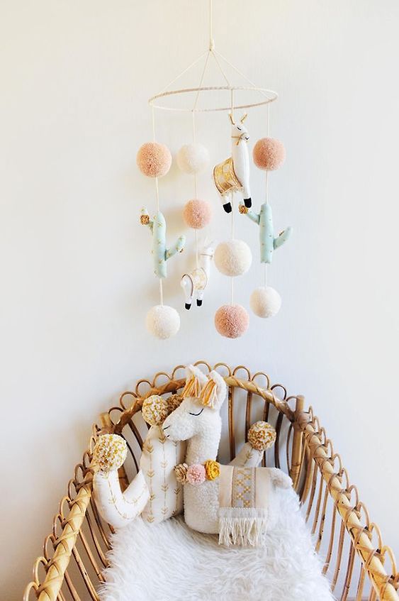 a pastel desert mobile with cacti, pompoms and llamas is a cool idea for a boho or desert nursery