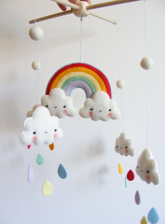 a pretty and bright mobile with a rainbow, clouds and colorful felt raindrops is a cool and fun idea for any nurseries