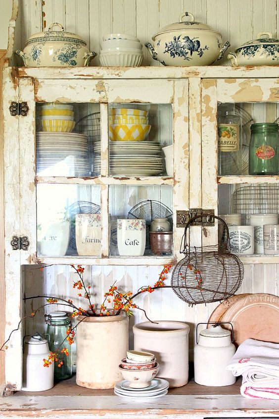 a rustic shabby chic kitchen in neutrals, with glass cabinets, beadboard walls, vintage pottery and porcelain for beautiful decor