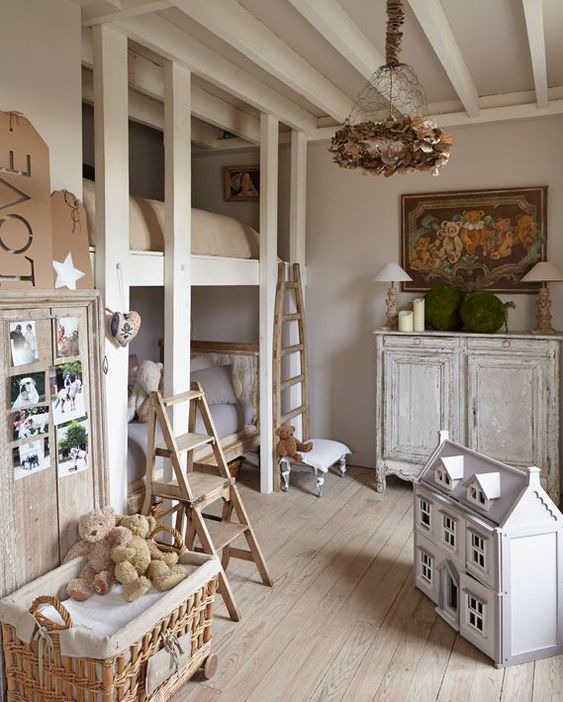 a shabby chic kid's room with dove grey walls, shabby chic furniture, lamps, a floral chandelier, toys in baskets