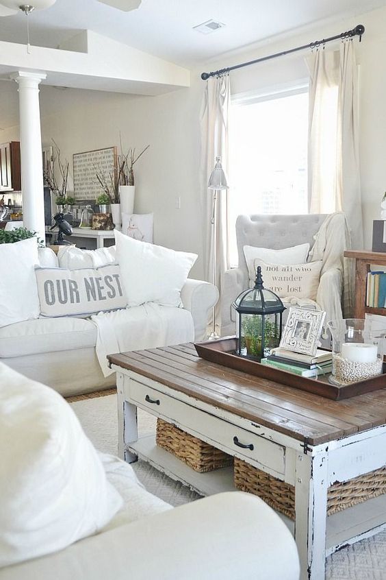 a shabby farmhouse living room with elegant furniture, a low table with a wooden tabletop, lanterns and candles