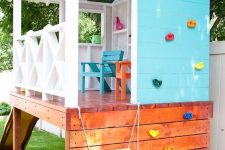 a simple outdoor plyahouse with a climbing wall, colorful furniture, a slide is a great activity spot for kids