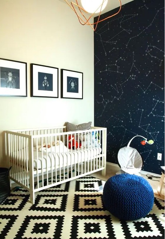 a space-themed nursery with a constellation statement wall, fun artworks and a navy pouf
