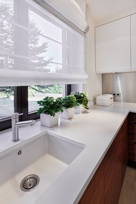 a stylish contemporary kitchen with semi sheer Roman shades that add coziness and don't block the views