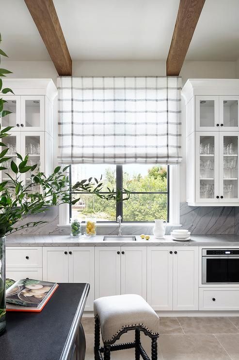 a subtle grey and white plaid Roman shade is a cool accent and addition of a print to the farmhouse space is lovely